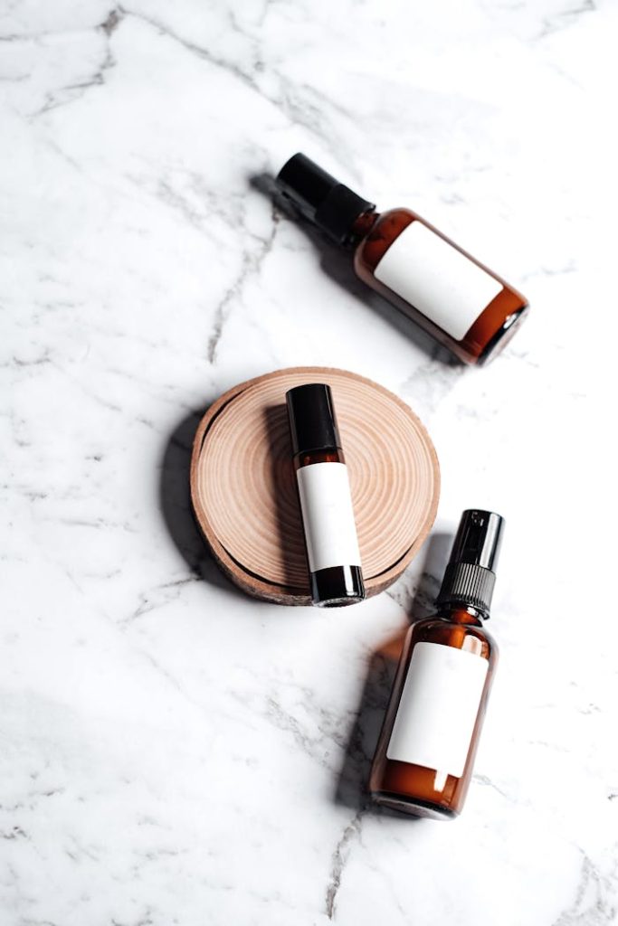 A set of skincare product bottles displayed on a marble surface with a wooden accent.