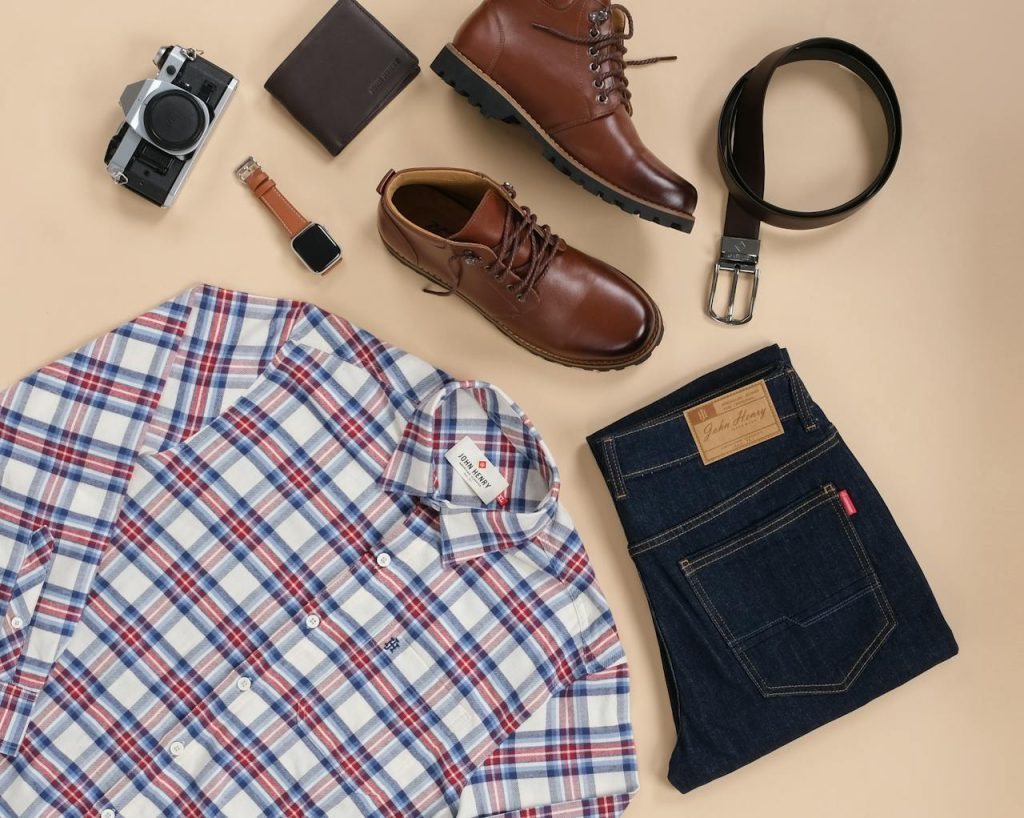Stylish flat lay of mens outfit essentials with accessories on a beige background.
